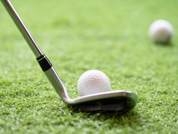 Selective,Golf,Club,And,Golf,Ball,On,Green,Grass,Background.iron